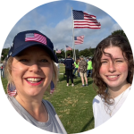 Picture of Lanette and girl in front of a Veterans Memorial.